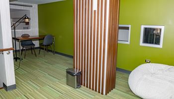 a room with a green wall and a white bed